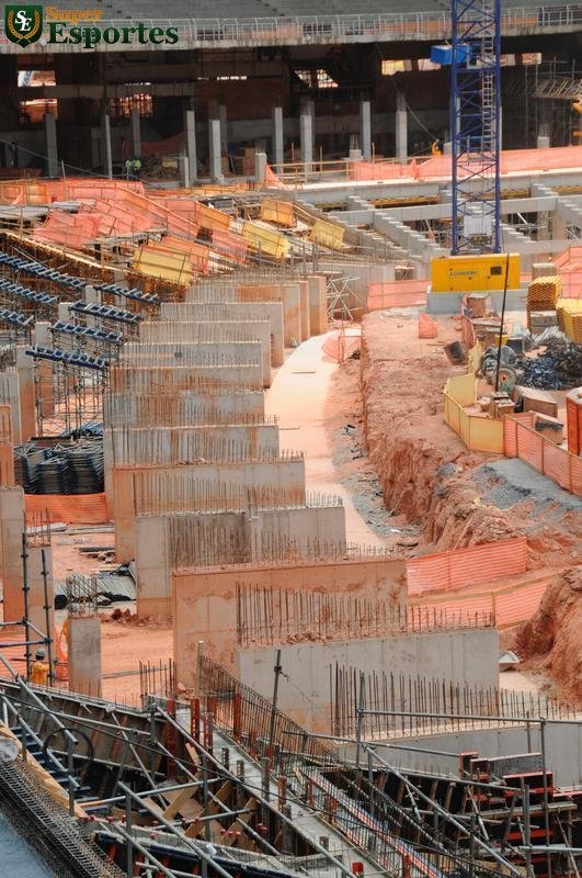 06/03/2012 - No interior, comea a construo efetiva do anel inferior, com assentos mais prximos ao gramado. Guindastes ajudam operrios a encaixar as peas de concreto armado.