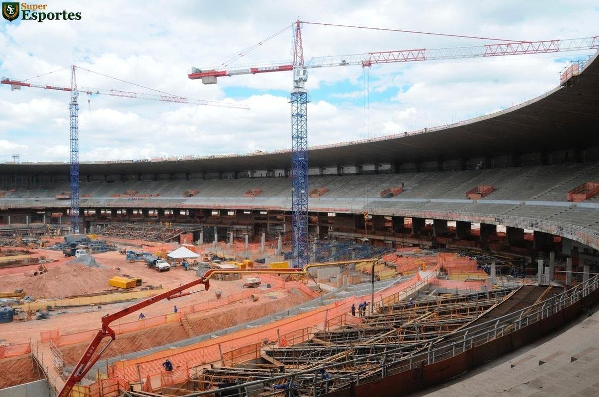 06/03/2012 - No interior, comea a construo efetiva do anel inferior, com assentos mais prximos ao gramado. Guindastes ajudam operrios a encaixar as peas de concreto armado.