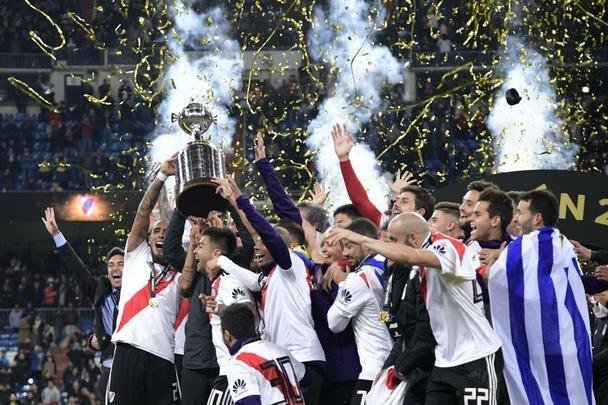 Depois da vitória por 3 a 1 sobre o Boca, jogadores do River Plate erguem a taça da Libertadores no Santiago Bernabéu, em Madri, e fazem a festa com o tetracampeonato continental