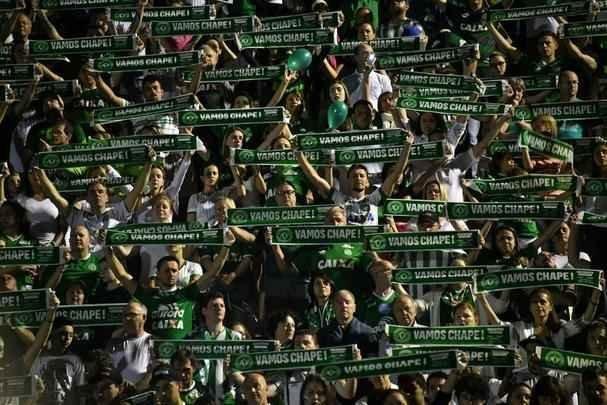 Foi na Arena ndio Cond que a Chapecoense deixou o 'anonimato' para ganhar os coraes de todos os brasileiros. Em seu estdio, o Verdo do Oeste mostrou toda sua valentia ao permanecer por trs anos seguidos na Srie A e, consequentemente, alcanar a deciso da Copa Sul-Americana. Pelo caminho ficaram gigantes como os argentinos Independiente e San Lorenzo e o colombiano Junior Barranquilla. Restava apenas o poderoso Atltico Nacional, melhor clube da atualidade na Amrica do Sul. Dentro de campo, a Chape no pde dar sequncia  sua bravura, pois acabou vitimada por um acidente areo que matou quase toda sua delegao nas proximidades de Medelln, na Colmbia. Mas, se depender do amor de uma multido, o clube renascer. A mesma Arena Cond que foi palco de trs acessos - da Srie D para a C, em 2009; da C para a B, em 2012; e da B para a A, em 2013 -  o local onde milhares de torcedores prestam as ltimas homenagens aos falecidos. Sempre, claro, com a esperana de que a agremiao se reerguer e dar continuidade ao belo trabalho recente. Vamos, vamos Chape!!! (CRDITO DAS IMAGENS: NELSON ALMEIDA/AFP)