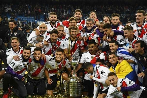 Depois da vitória por 3 a 1 sobre o Boca, jogadores do River Plate erguem a taça da Libertadores no Santiago Bernabéu, em Madri, e fazem a festa com o tetracampeonato continental