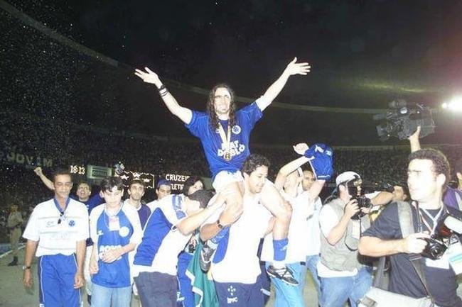 Nos ombros dos companheiros de equipe, o dolo cruzeirense cumprimenta a torcida