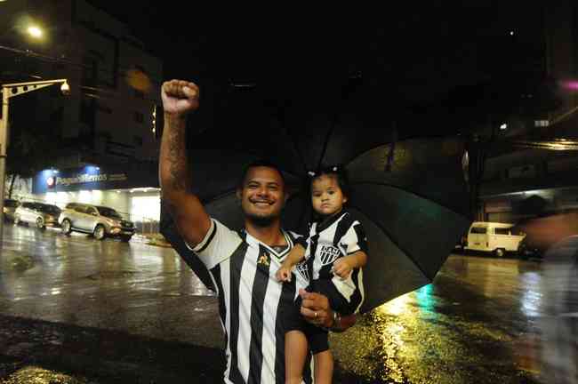 Henrique Pereira, 34, torce com e a filha Mariana, de 1 ano e 11 meses, no colo