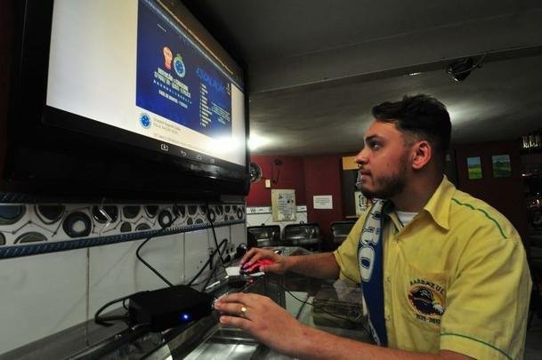 Em bares de Belo Horizonte, torcedores do Cruzeiro tiveram que recorrer a celulares e notebooks para assistir ao duelo com o Huracn, pela Copa Libertadores, via Facebook. Transmisses com o tradicional telo oferecidas por alguns estabelecimentos travaram muito e at foram tiradas do ar. Na verso mobile, resultado foi melhor. Na foto, Eduardo Arajo, funcionrio do Barbazul, preparando a transmisso.