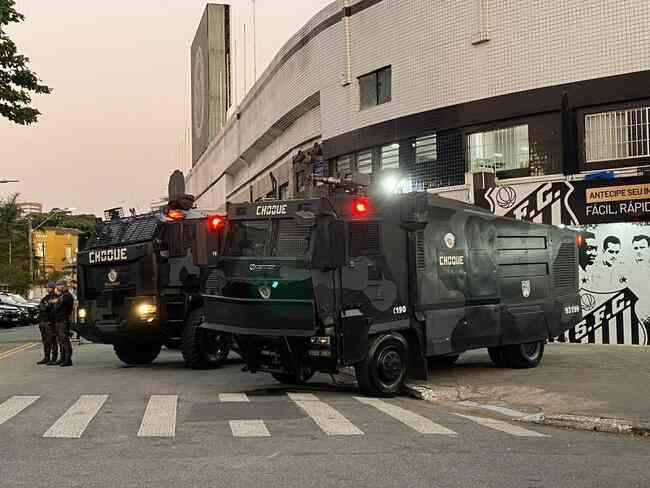 Dois Guardiões, caminhões blindados do Choque, estão posicionados na frente da Vila