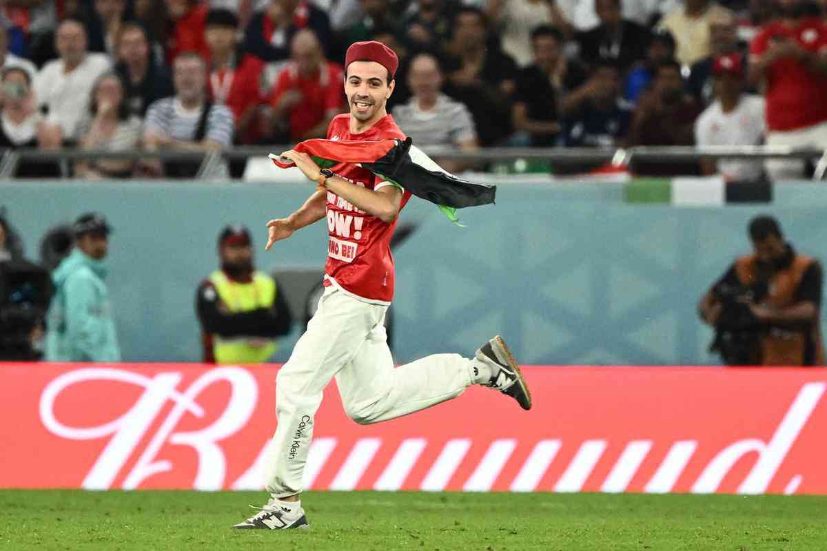 Homem invade campo do jogo Tunsia x Frana, no Estdio Cidade da Educao, em Doha, com a bandeira da Palestina