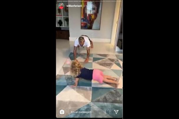 Volante Willian Farias improvisa em treino físico na sala de casa - acompanhado da filha