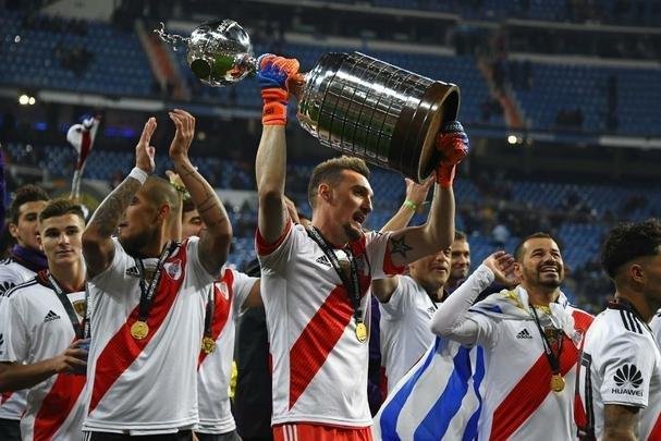 Depois da vitória por 3 a 1 sobre o Boca, jogadores do River Plate erguem a taça da Libertadores no Santiago Bernabéu, em Madri, e fazem a festa com o tetracampeonato continental
