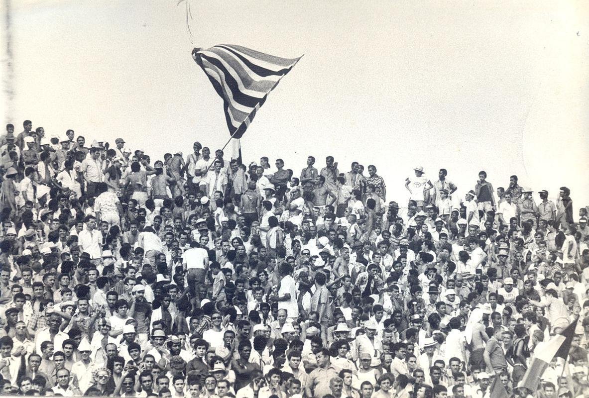 Arquibancadas lotadas para Santa Cruz x Flamengo, com bandeira tremulando no alto dos degraus.
