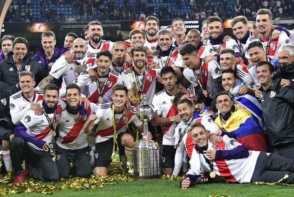 Depois da vitória por 3 a 1 sobre o Boca, jogadores do River Plate erguem a taça da Libertadores no Santiago Bernabéu, em Madri, e fazem a festa com o tetracampeonato continental