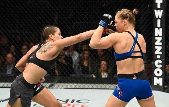 Amanda Nunes (luvas vermelhas) venceu Ronda Rousey por nocaute tcnico em 48 segundos e manteve o cinturo dos galos