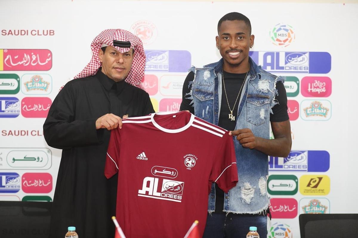 Emprestado at maio pelo Atltico, o atacante Denlson foi recebido com flores no Aeroporto Internacional King Khalid, em Riade, na Arbia Saudita, nesse domingo. Logo depois, o jogador de 23 anos passou por exames mdicos e assinou contrato com o Al Faisaly, que j o apresentou oficialmente. Pelo negcio, o Atltico receber uma compensao financeira. O acordo tambm prev o valor fixo para que os rabes contratem o centroavante em definitivo. Navegue na galeria para ver as fotos.