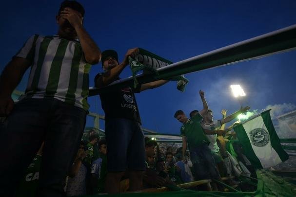 Foi na Arena ndio Cond que a Chapecoense deixou o 'anonimato' para ganhar os coraes de todos os brasileiros. Em seu estdio, o Verdo do Oeste mostrou toda sua valentia ao permanecer por trs anos seguidos na Srie A e, consequentemente, alcanar a deciso da Copa Sul-Americana. Pelo caminho ficaram gigantes como os argentinos Independiente e San Lorenzo e o colombiano Junior Barranquilla. Restava apenas o poderoso Atltico Nacional, melhor clube da atualidade na Amrica do Sul. Dentro de campo, a Chape no pde dar sequncia  sua bravura, pois acabou vitimada por um acidente areo que matou quase toda sua delegao nas proximidades de Medelln, na Colmbia. Mas, se depender do amor de uma multido, o clube renascer. A mesma Arena Cond que foi palco de trs acessos - da Srie D para a C, em 2009; da C para a B, em 2012; e da B para a A, em 2013 -  o local onde milhares de torcedores prestam as ltimas homenagens aos falecidos. Sempre, claro, com a esperana de que a agremiao se reerguer e dar continuidade ao belo trabalho recente. Vamos, vamos Chape!!! (CRDITO DAS IMAGENS: NELSON ALMEIDA/AFP)