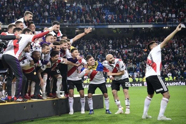Depois da vitória por 3 a 1 sobre o Boca, jogadores do River Plate erguem a taça da Libertadores no Santiago Bernabéu, em Madri, e fazem a festa com o tetracampeonato continental