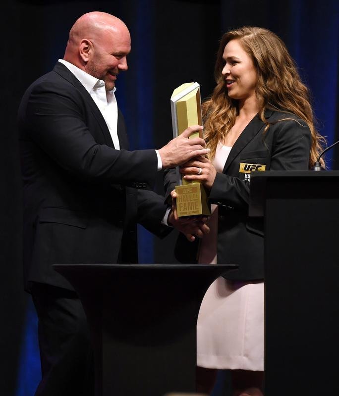 Ex-campe do peso galo, Ronda Rousey se tornou primeira mulher a entrar para o Hall da Fama do UFC. Ela recebe a honraria das mos do presidente Dana White