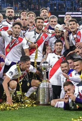 Depois da vitória por 3 a 1 sobre o Boca, jogadores do River Plate erguem a taça da Libertadores no Santiago Bernabéu, em Madri, e fazem a festa com o tetracampeonato continental