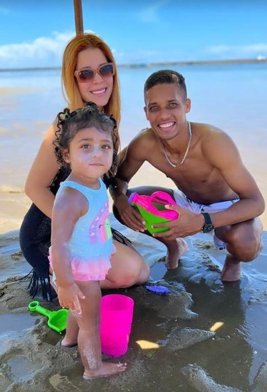 Pedrinho ao lado da famlia na praia em Macei 