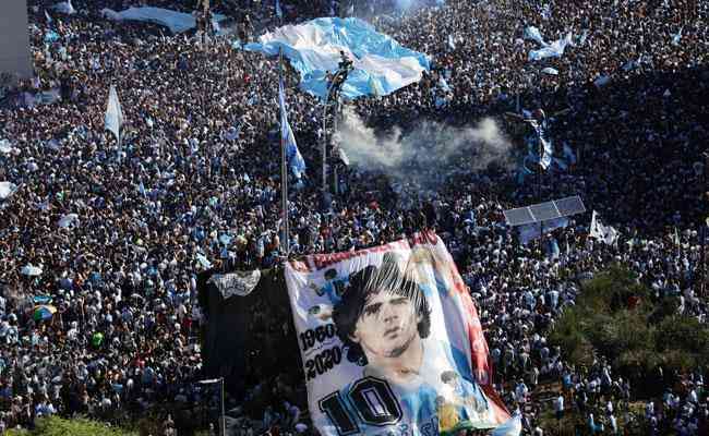 Rosto de Maradona em bandeira no meio da multido