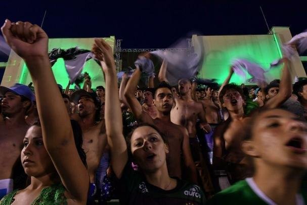 Foi na Arena ndio Cond que a Chapecoense deixou o 'anonimato' para ganhar os coraes de todos os brasileiros. Em seu estdio, o Verdo do Oeste mostrou toda sua valentia ao permanecer por trs anos seguidos na Srie A e, consequentemente, alcanar a deciso da Copa Sul-Americana. Pelo caminho ficaram gigantes como os argentinos Independiente e San Lorenzo e o colombiano Junior Barranquilla. Restava apenas o poderoso Atltico Nacional, melhor clube da atualidade na Amrica do Sul. Dentro de campo, a Chape no pde dar sequncia  sua bravura, pois acabou vitimada por um acidente areo que matou quase toda sua delegao nas proximidades de Medelln, na Colmbia. Mas, se depender do amor de uma multido, o clube renascer. A mesma Arena Cond que foi palco de trs acessos - da Srie D para a C, em 2009; da C para a B, em 2012; e da B para a A, em 2013 -  o local onde milhares de torcedores prestam as ltimas homenagens aos falecidos. Sempre, claro, com a esperana de que a agremiao se reerguer e dar continuidade ao belo trabalho recente. Vamos, vamos Chape!!! (CRDITO DAS IMAGENS: NELSON ALMEIDA/AFP)