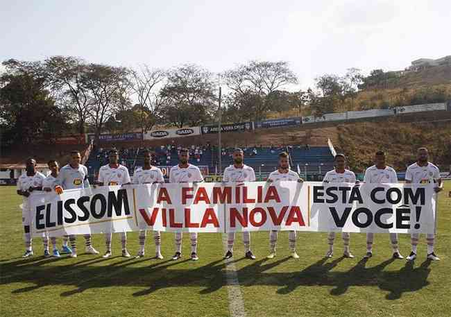 Jogadores do Villa Nova seguram faixa manifestando apoio ao goleiro Elisson 