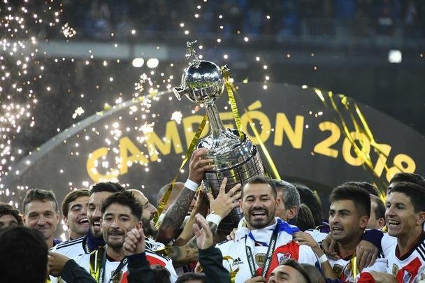 Depois da vitória por 3 a 1 sobre o Boca, jogadores do River Plate erguem a taça da Libertadores no Santiago Bernabéu, em Madri, e fazem a festa com o tetracampeonato continental