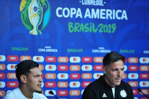 Tcnicos de Argentina e Paraguai, juntos de um jogador de cada equipe, em entrevista no Mineiro