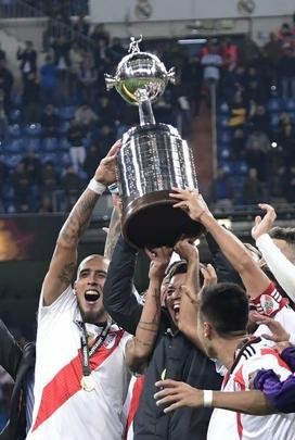 Depois da vitória por 3 a 1 sobre o Boca, jogadores do River Plate erguem a taça da Libertadores no Santiago Bernabéu, em Madri, e fazem a festa com o tetracampeonato continental