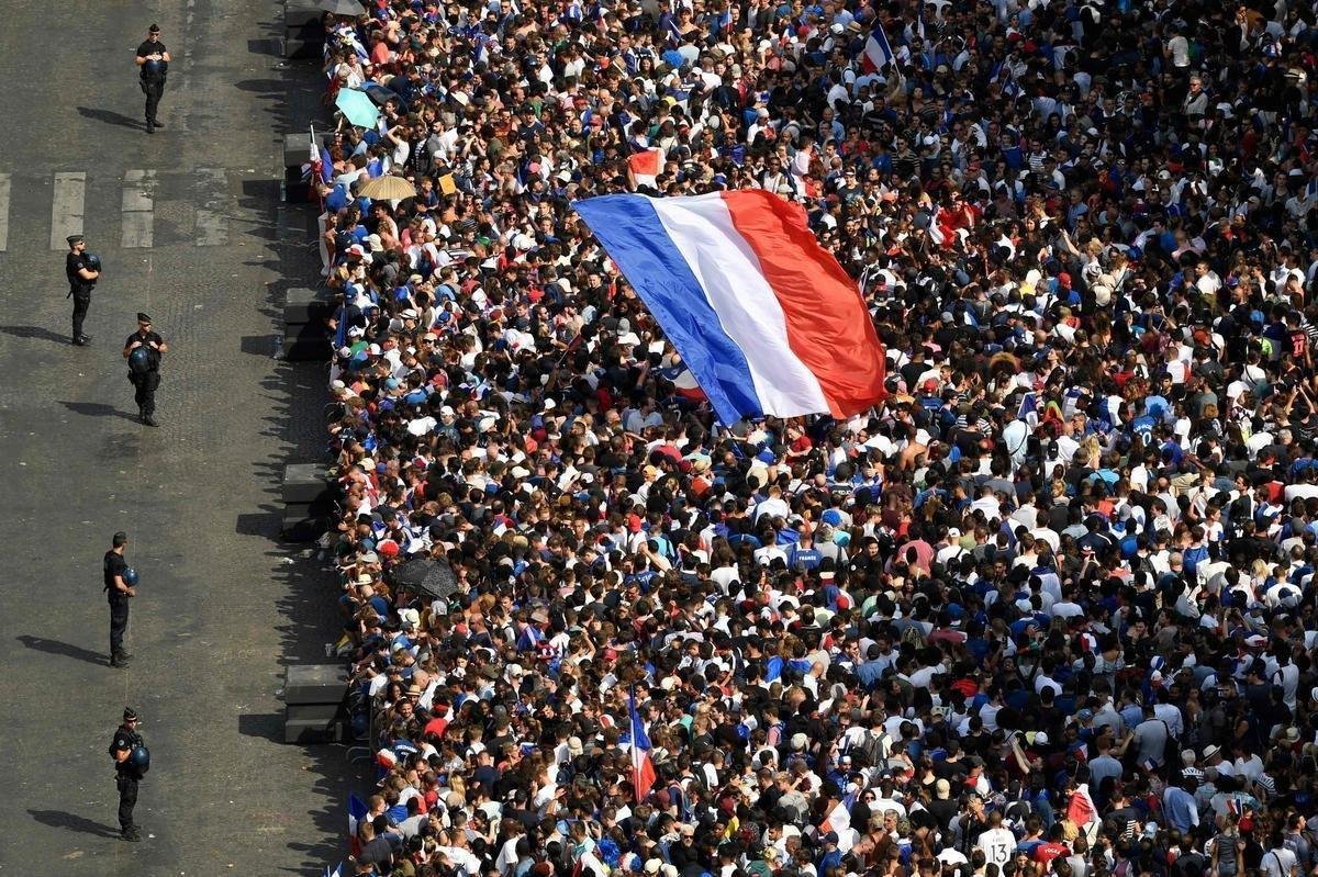 Campees do mundo desfilaram nas ruas de Paris nesta segunda, exibindo a taa da Copa para milhares de torcedores