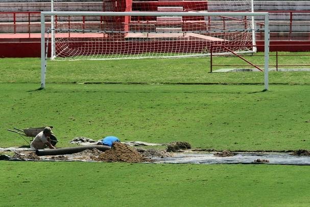 Funcionários do clube trabalham para recuperar o gramado após as fortes chuvas que caíram no Recife