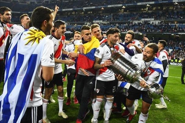 Depois da vitória por 3 a 1 sobre o Boca, jogadores do River Plate erguem a taça da Libertadores no Santiago Bernabéu, em Madri, e fazem a festa com o tetracampeonato continental