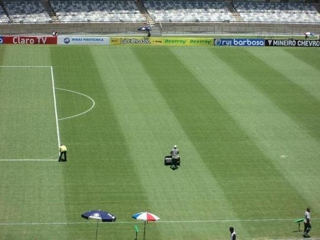 14 horas - Funcionrios da Minas Arena reforam marcaes de cal no gramado depois da forte chuva de sbado