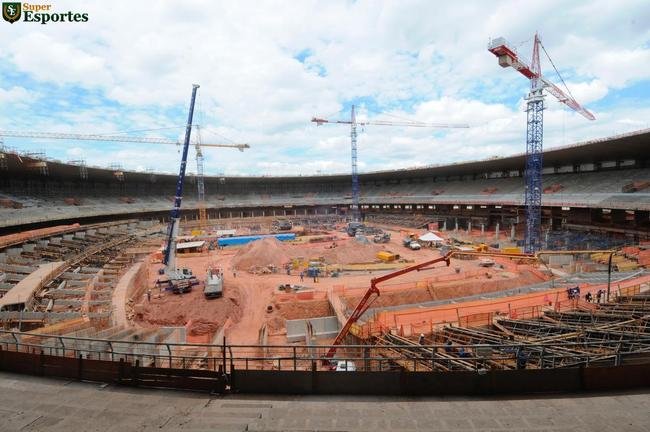 06/03/2012 - No interior, comea a construo efetiva do anel inferior, com assentos mais prximos ao gramado. Guindastes ajudam operrios a encaixar as peas de concreto armado.