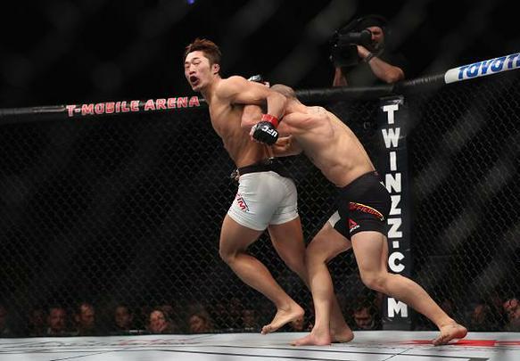 Dong Hyun Kim (luvas vermelhas) venceu Tarec Saffiedine por deciso dividida (30-27, 28-29, 29-28)