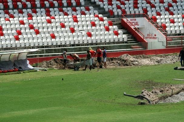 Funcionários do clube trabalham para recuperar o gramado após as fortes chuvas que caíram no Recife