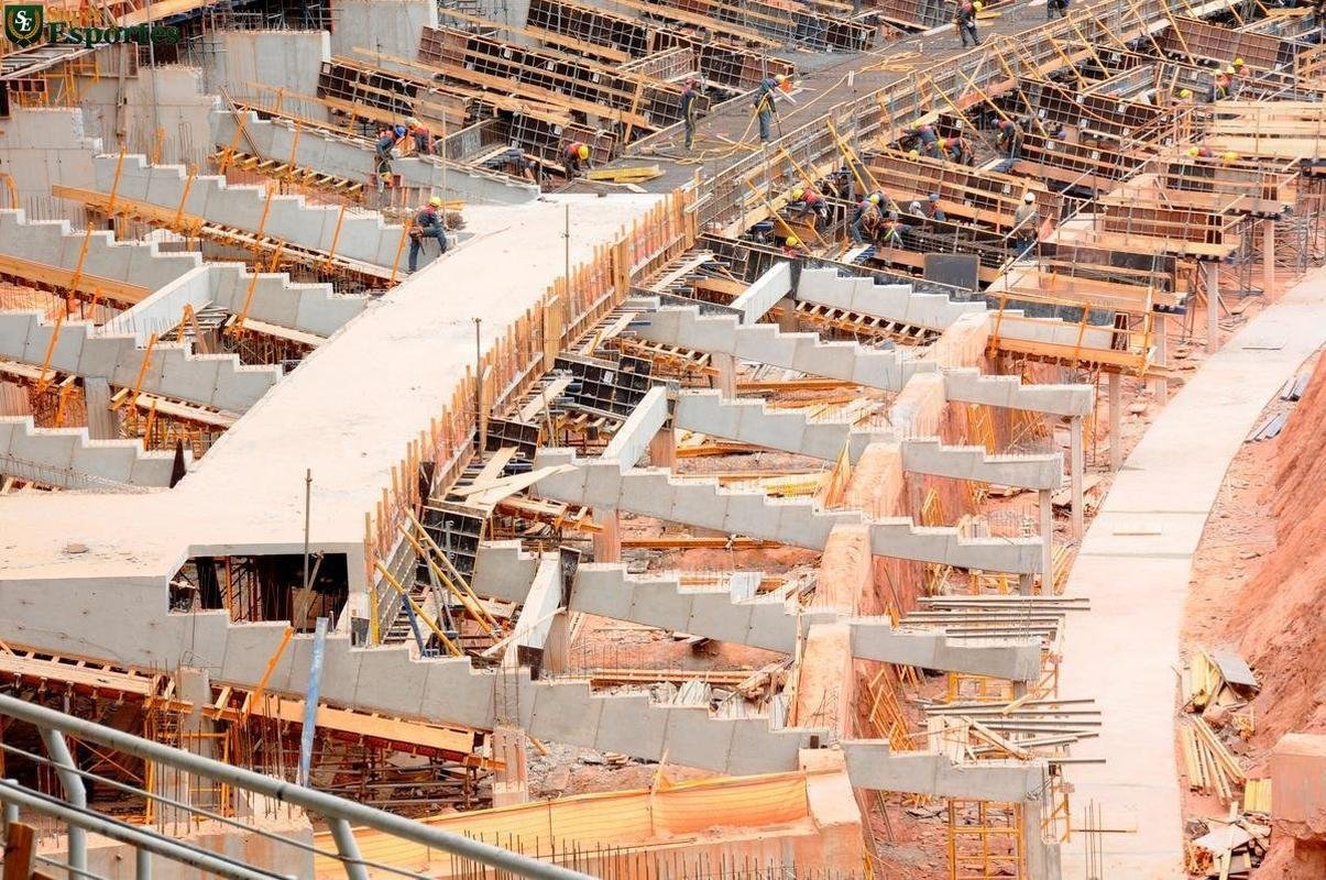 06/03/2012 - No interior, comea a construo efetiva do anel inferior, com assentos mais prximos ao gramado. Guindastes ajudam operrios a encaixar as peas de concreto armado.