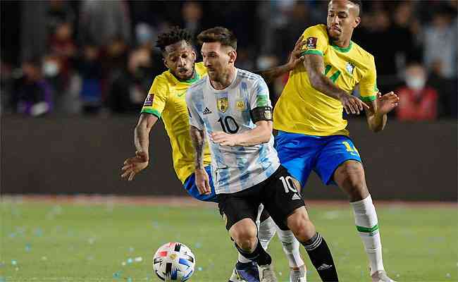 Messi  cercado por Fred e der Milito: bem marcado, craque teve atuao discreta no clssico