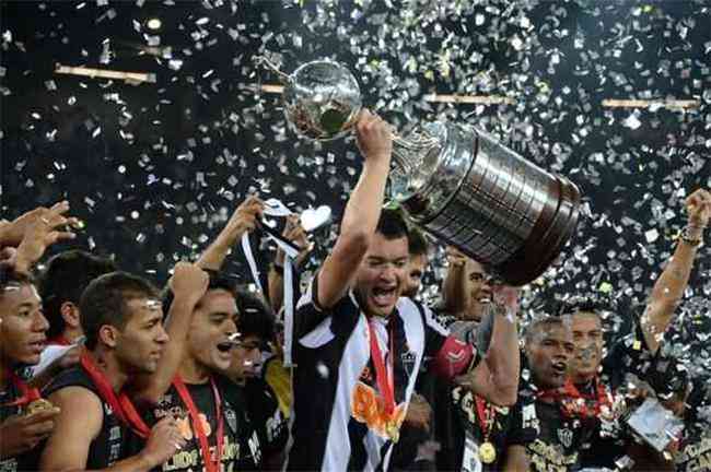 O capitão do Atlético, Réver, ergue a taça de campeão da Libertadores 2013; título valeu vaga no torneio continental de 2014 