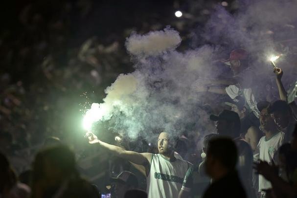 Foi na Arena ndio Cond que a Chapecoense deixou o 'anonimato' para ganhar os coraes de todos os brasileiros. Em seu estdio, o Verdo do Oeste mostrou toda sua valentia ao permanecer por trs anos seguidos na Srie A e, consequentemente, alcanar a deciso da Copa Sul-Americana. Pelo caminho ficaram gigantes como os argentinos Independiente e San Lorenzo e o colombiano Junior Barranquilla. Restava apenas o poderoso Atltico Nacional, melhor clube da atualidade na Amrica do Sul. Dentro de campo, a Chape no pde dar sequncia  sua bravura, pois acabou vitimada por um acidente areo que matou quase toda sua delegao nas proximidades de Medelln, na Colmbia. Mas, se depender do amor de uma multido, o clube renascer. A mesma Arena Cond que foi palco de trs acessos - da Srie D para a C, em 2009; da C para a B, em 2012; e da B para a A, em 2013 -  o local onde milhares de torcedores prestam as ltimas homenagens aos falecidos. Sempre, claro, com a esperana de que a agremiao se reerguer e dar continuidade ao belo trabalho recente. Vamos, vamos Chape!!! (CRDITO DAS IMAGENS: DOUGLAS MAGNO/AFP)