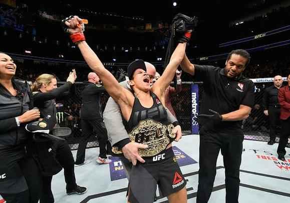Amanda Nunes (luvas vermelhas) venceu Ronda Rousey por nocaute tcnico em 48 segundos e manteve o cinturo dos galos