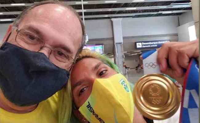 Ana Marcela Cunha comemora o ouro na maratona aqutica nos Jogos Olmpicos de Tquio com o pai