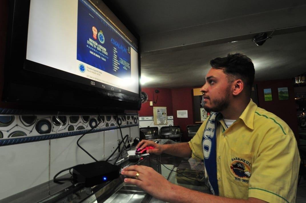Em bares de Belo Horizonte, torcedores do Cruzeiro tiveram que recorrer a celulares e notebooks para assistir ao duelo com o Huracn, pela Copa Libertadores, via Facebook. Transmisses com o tradicional telo oferecidas por alguns estabelecimentos travaram muito e at foram tiradas do ar. Na verso mobile, resultado foi melhor. Na foto, Eduardo Arajo, funcionrio do Barbazul, preparando a transmisso.