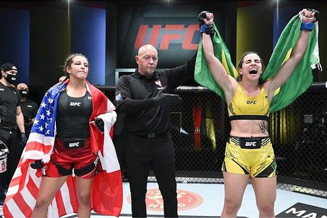 Norma Dumont foi declarada vencedora na decisão dividida e comemorou com a bandeira do Brasil