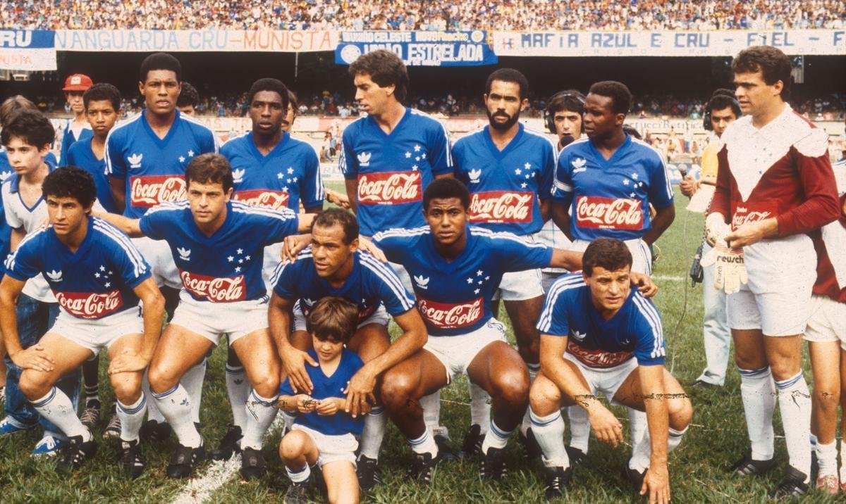 A Topper não durou muito e, no fim de 1985, o Cruzeiro já vestia uniformes de outro fornecedor de material esportivo: a alemã Adidas. Com a troca, as tradicionais três listras da Adidas apareceram nas mangas da camisa, sendo a única mudança aparente para os uniformes da Topper. Os patrocinadores másters seguiram sem um padrão, chegando até a ser um espaço vazio da camisa durante maior parte desse período. Mas, em 1988, a primeira empresa internacional ocupou espaço como patrocínio máster: a marca de bebidas Coca-Cola, que tinha a logo estampada na barriga e nas costas, acima do número. Com ela, uma padronização por tempo de exposição passou a ser mais clara, diferentemente dos anos anteriores, que teve vários patrocinadores pontuais por curtos períodos.