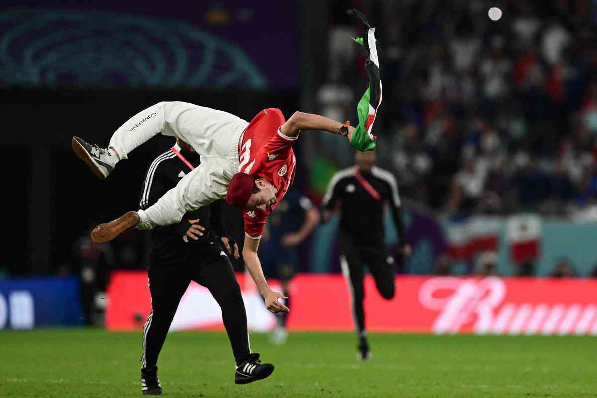 Homem invade campo do jogo Tunsia x Frana, no Estdio Cidade da Educao, em Doha, com a bandeira da Palestina