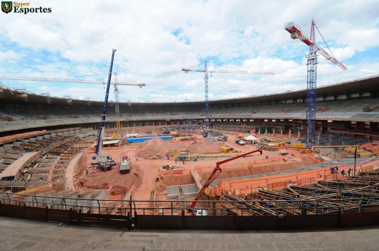 06/03/2012 - No interior, comea a construo efetiva do anel inferior, com assentos mais prximos ao gramado. Guindastes ajudam operrios a encaixar as peas de concreto armado.