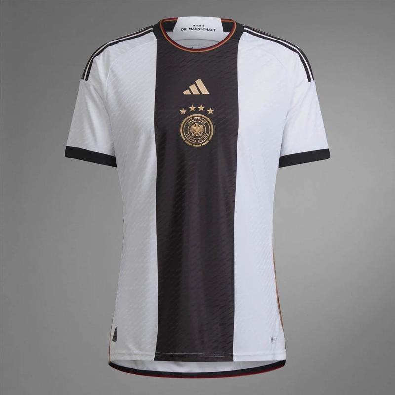 A camisa I da Alemanha para a Copa do Catar  branca com uma faixa preta no centro e foi produzida pela Adidas