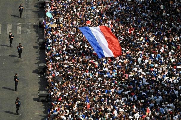 Campees do mundo desfilaram nas ruas de Paris nesta segunda, exibindo a taa da Copa para milhares de torcedores