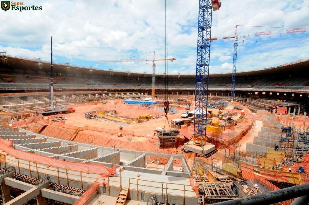 06/03/2012 - No interior, comea a construo efetiva do anel inferior, com assentos mais prximos ao gramado. Guindastes ajudam operrios a encaixar as peas de concreto armado.