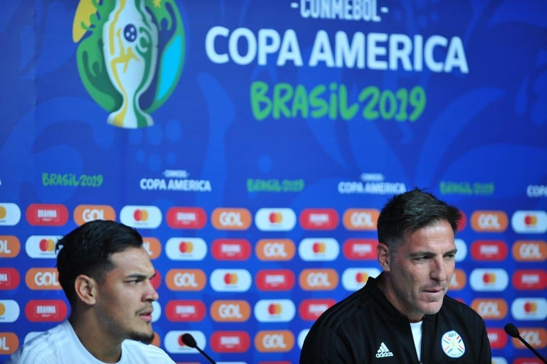 Tcnicos de Argentina e Paraguai, juntos de um jogador de cada equipe, em entrevista no Mineiro