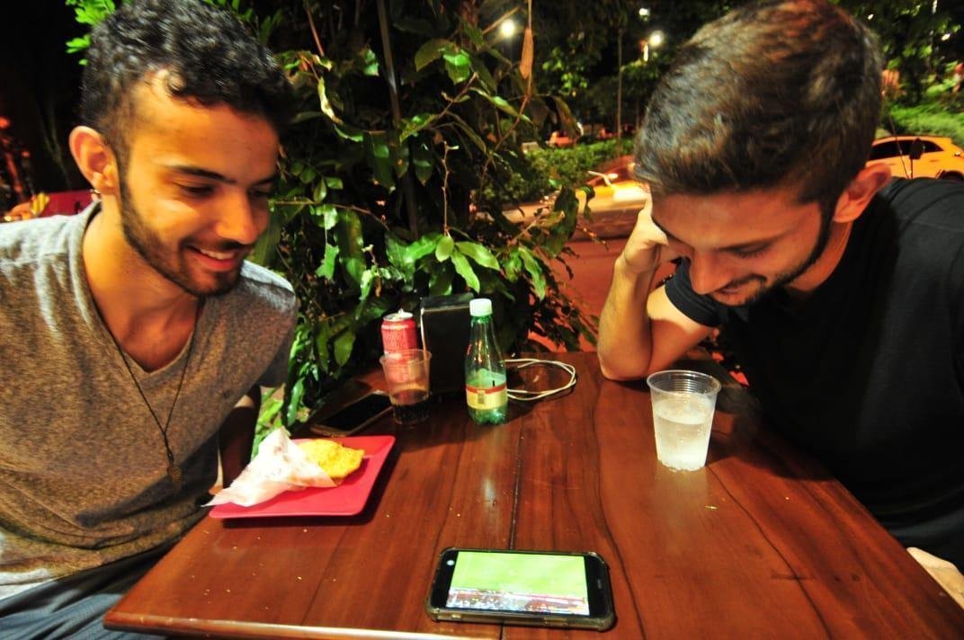 Em bares de Belo Horizonte, torcedores do Cruzeiro tiveram que recorrer a celulares e notebooks para assistir ao duelo com o Huracn, pela Copa Libertadores, via Facebook. Transmisses com o tradicional telo oferecidas por alguns estabelecimentos travaram muito e at foram tiradas do ar. Na verso mobile, resultado foi melhor. Na foto, Gabriel Nogueira e Abdala Magalhes vendo pelo smartphone.